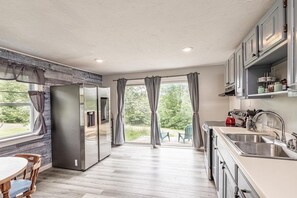 A modern kitchen with a built-in refrigerator, a sink, and a dining area with a table and chairs.