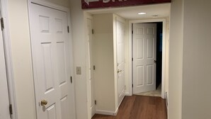 A hallway with white doors, a wooden floor, and a sign above indicating 'SKI LIFT'. - Winterplace Condo Steps away from slopes (Ludlow)