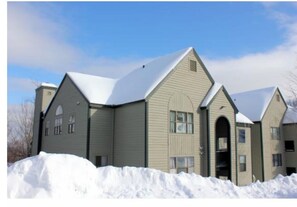 A two-story building with a gabled roof and a central entrance.