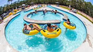 A swimming pool with multiple lanes and people using inflatable rings. - Biloxi Bay Adventure: Stay in Our Comfortable Camper Rental (Biloxi)