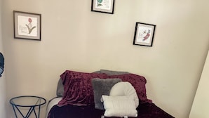 A bedroom with a purple velvet bedspread, a small round table, and three framed motivational posters on the wall. - Braves Stadium  (Smyrna)