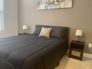 Relax in a serene bedroom with a large bed, two bedside tables, and a beautiful painting above.