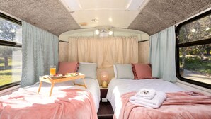 Un interior acogedor con dos camas, un espacio para desayunar y vistas a través de las ventanas.