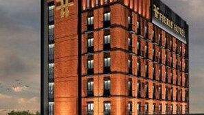 A modern hotel with a brick facade, multiple floors, and a prominent sign reading "FIERIS HOTEL". - Fieris Hotel Rawamangun (Jakarta)