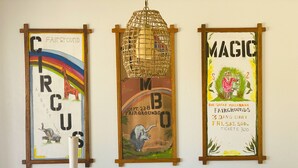 Un mur orné de trois affiches encadrées : « Cirque », « MB » et « Magie ».