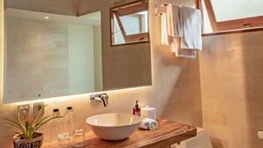 A bathroom with a wooden vanity, a large mirror, a white sink, a toilet, and a skylight. - Villa Avyathi at Anandathu Villas - Tropical 2BR Contemporary Villa in Canggu (Bali)