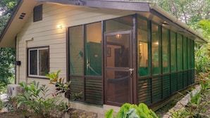 Une maison avec une véranda grillagée, une porte et une fenêtre.