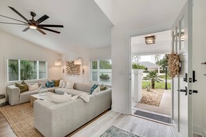 Relax in this stylish living room with a large L-shaped sofa, coffee table, and ceiling fan.