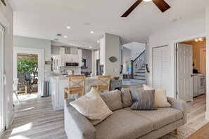 Relax in this inviting living space with a sofa, chair, and modern ceiling fan.