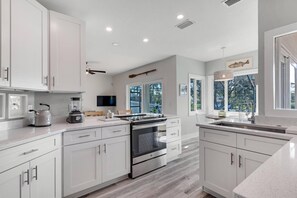 Enjoy cooking in this well-equipped kitchen with a stainless steel range, large island, and flat-screen TV.