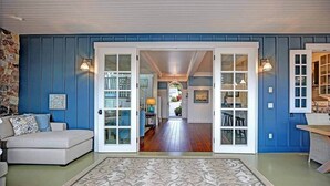 A room with a blue wall, a white door, a patterned rug, and a sofa.