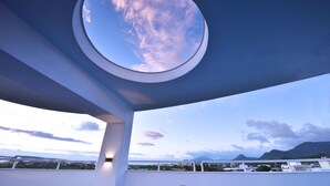 Un tragaluz circular con vistas al cielo y al paisaje distante.