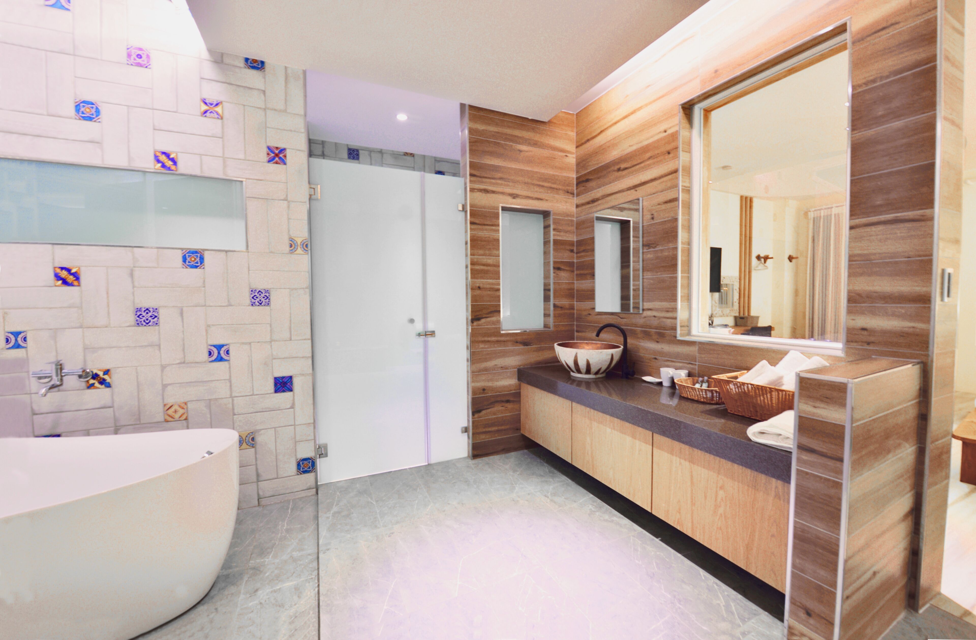 Une salle de bain moderne avec une baignoire sur pieds, un meuble-lavabo en bois doté d’un grand miroir et un pare-feu en carreaux.