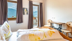 A bedroom with a bed, a desk, and a view of mountains. - Holiday Apartment "Dolomiten Winklerhof" with Mountain View, Garden & Wi-Fi (Villanders)