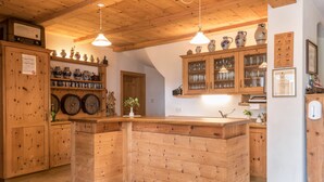 A wooden kitchen with a central island, wooden cabinets, and hanging light fixtures.