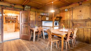 Un interior de madera con una mesa de comedor, sillas, una estantería y un ventanal.