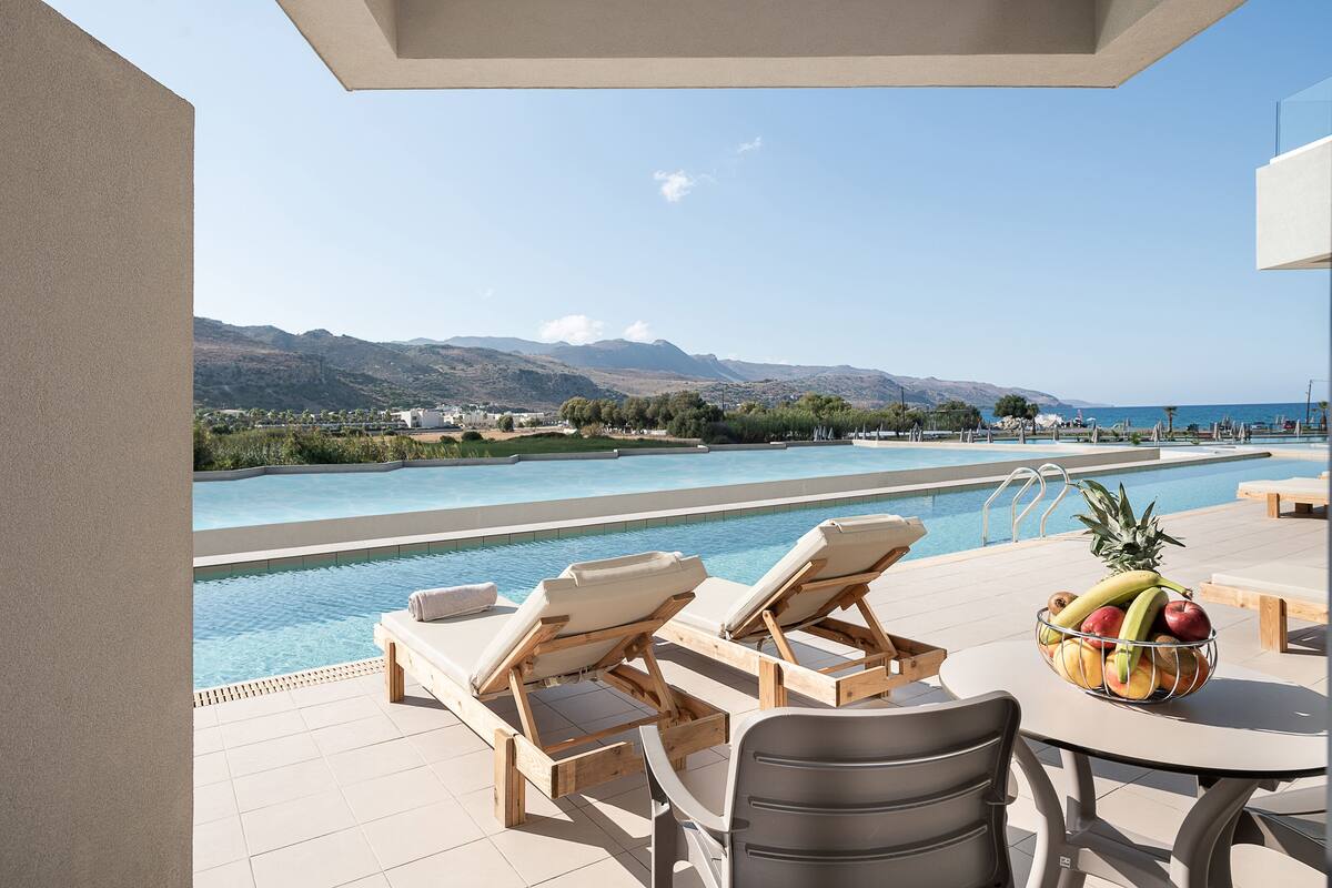 Ein Poolbereich mit Liegestühlen und einem Tisch mit Obstschale.