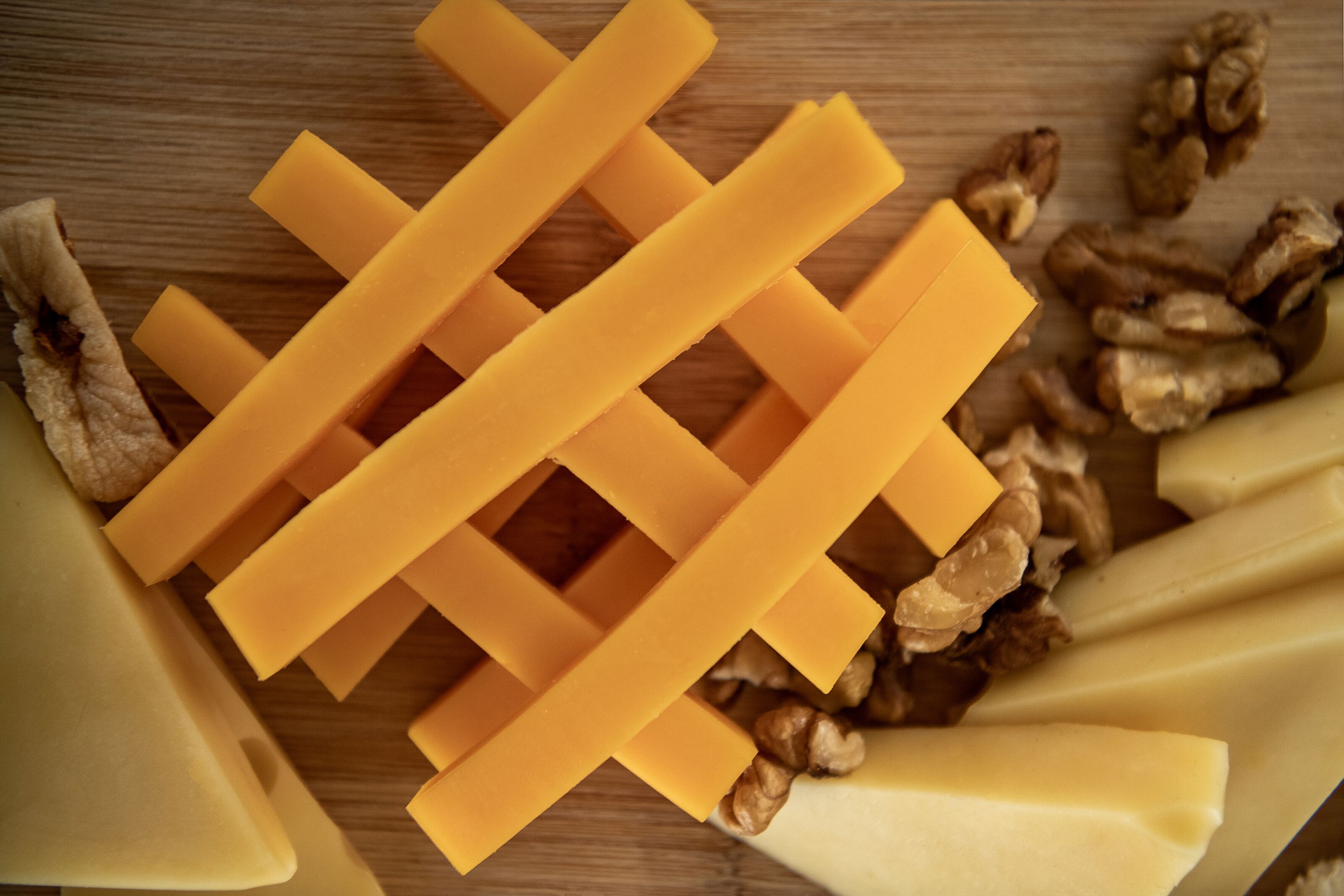 A wooden surface with cheese and walnuts.