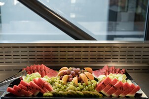A tray of assorted fruits including watermelon, grapes, and melon slices.