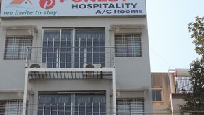 Un edificio con un letrero que indica Habitaciones Punest Hospitality, con aire acondicionado.