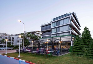 A modern building with outdoor seating and a pool. - Lucky Monkey Hotel (Antalya)