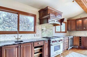 Enjoy cooking in this well-equipped kitchen with a large stove, ample counter space, and wooden cabinets.