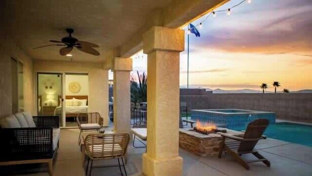 An outdoor patio area with a pool, seating, and a fire feature. - ❤️Modern 4BR Joshua Tree House w/ heated Pool! (Yucca Valley)