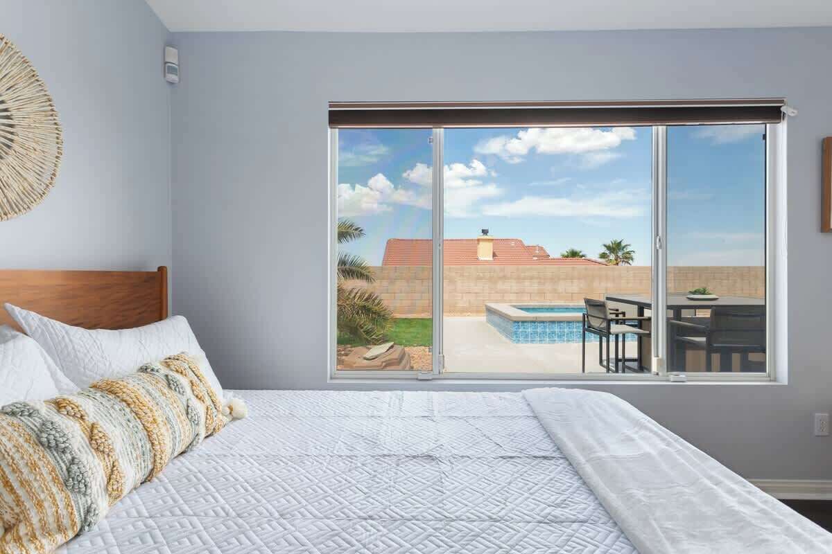 A bedroom with a large sliding glass door leading to a pool area.