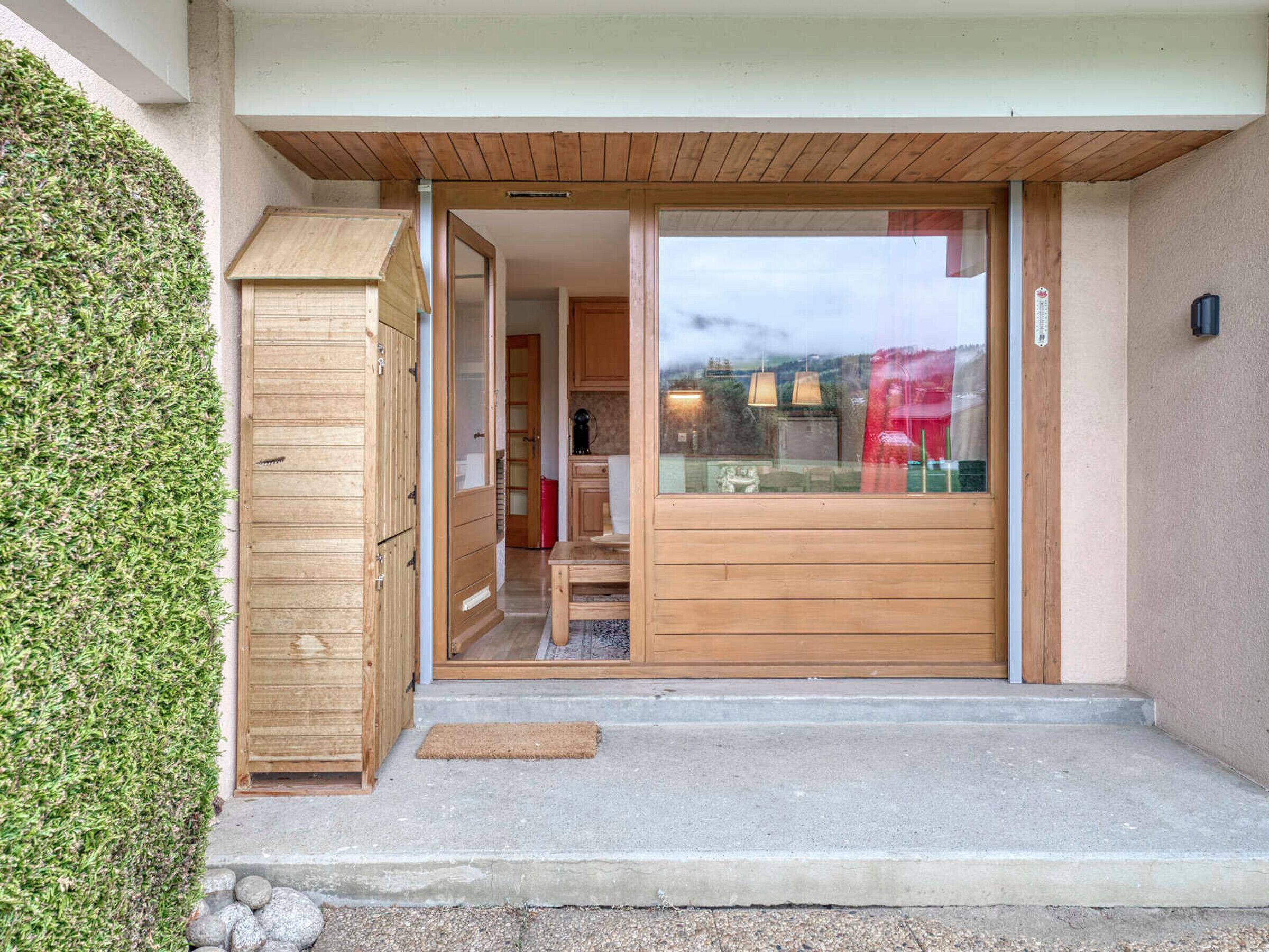 A wooden door leading into a room with a view of the outside.