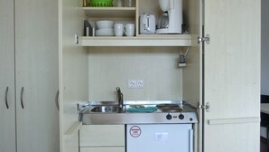 Une petite cuisine équipée d’un évier, d’une machine à café et d’un mini-réfrigérateur.