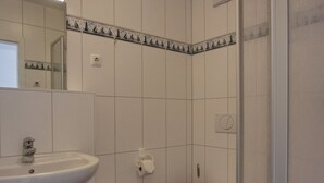 A bathroom with a white sink, a toilet, and a mirror. - KW21 "Südwind 2" - 1-room apartment for max. 2 persons, WLAN (Gelbensande)