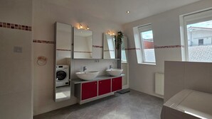 A bathroom with a washing machine, two sinks, a mirror, and a window. - Vacation apartment A3 - close to the beach - (84 m²) - three balconies and two (Graal-Müritz)