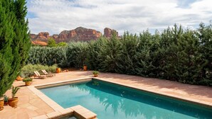 A swimming pool with a view of red rock formations in the background. - Gated Historic Estate • Pool, Spa & Artifacts (Sedona)