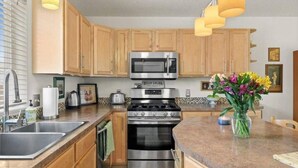 A modern kitchen with wooden cabinets, stainless steel appliances, and a granite countertop. - Charming Townhouse in the River Road Neighborhood - Pet friendly - Close to Downtown (Missoula)