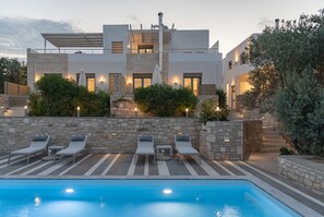 A modern building with a pool, stone walls, and outdoor seating. - Eco Villa, Serene Nature Retreat Near the Beach (Rethymno)