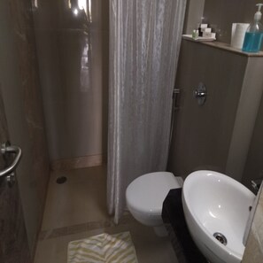 Deluxe kamer | Badkamer | Een douche, gratis toiletartikelen, badjassen, handdoeken