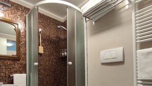 Ein modernes Badezimmer mit einer Duschkabine, einer weißen Toilette und einem Waschbecken.
