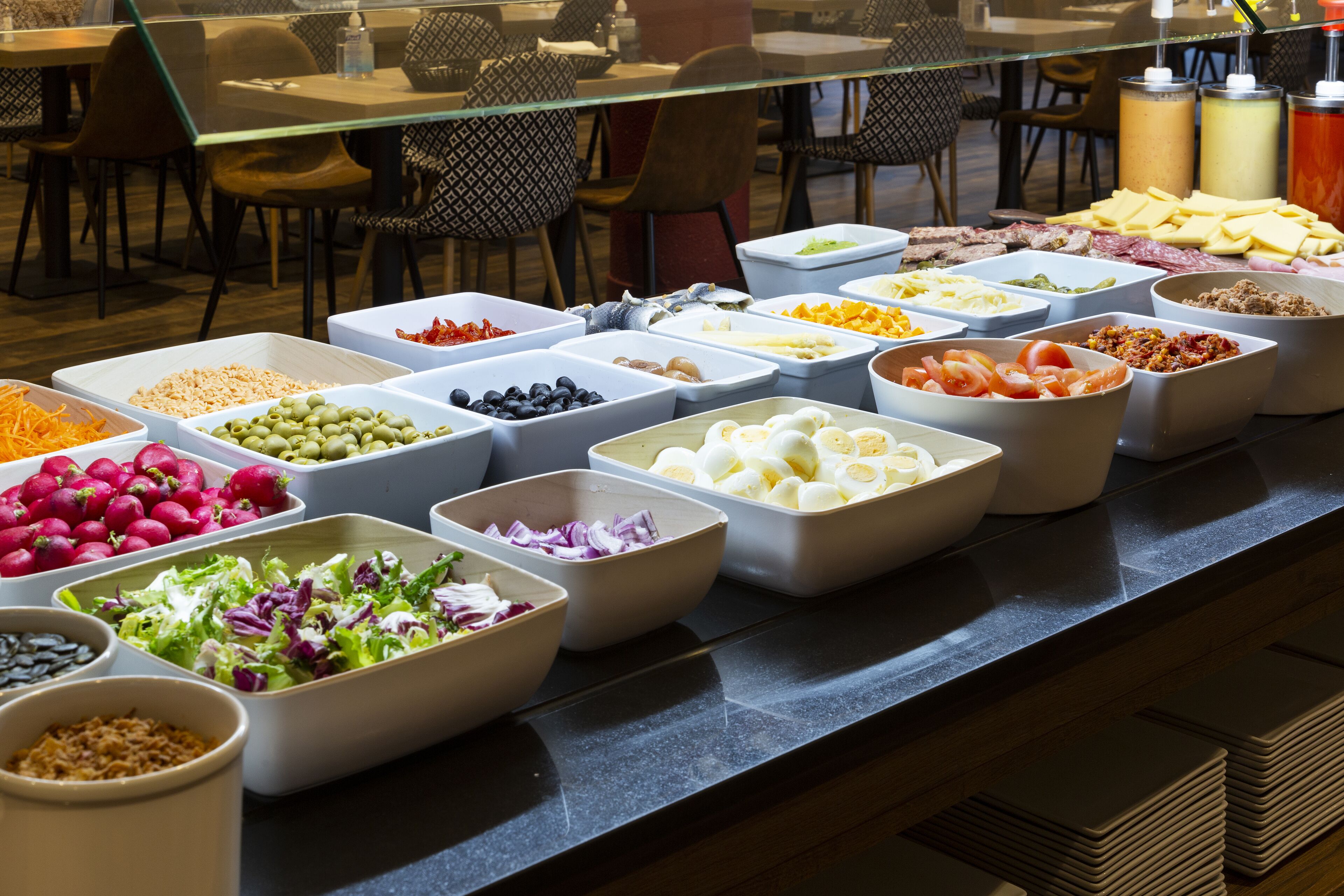 A buffet with various food items in bowls and containers.
