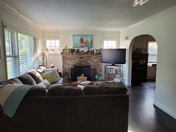 Relax in the cozy living room with a comfortable sofa, flat-screen TV, and brick fireplace.