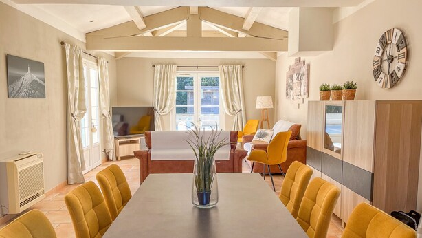 A modern living room with a dining table, yellow chairs, a sofa, and a TV. - 4-Bedroom Villa • Secure Pool • Air Conditioning • Provence – Bollène (Bollène)