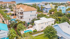A coastal residential area with a large building featuring multiple balconies and a swimming pool. - Private Pool ~ Porch ~ Fire Pit ~ Pet Friendly (Destin)