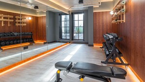 A gym with a bench press, dumbbells, and a squat rack. - Second Nature London Chiswick (London)