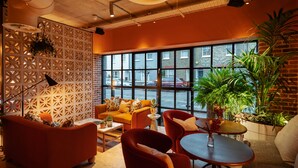 A modern interior with a sofa, chairs, a table, and potted plants. - Second Nature London Chiswick (London)