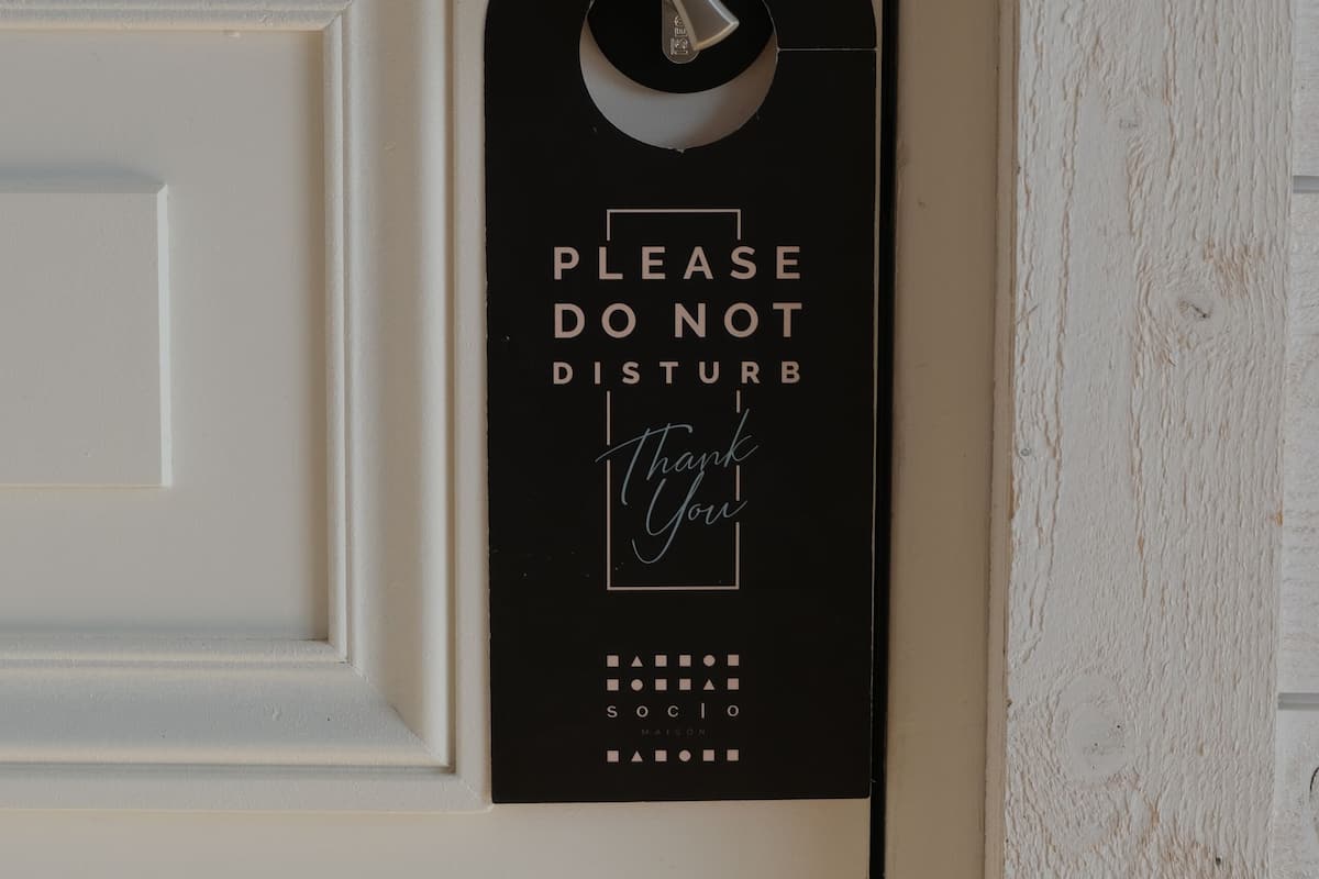 A door with a black sign that reads "PLEASE DO NOT DISTURB Thank you" and a keypad lock.