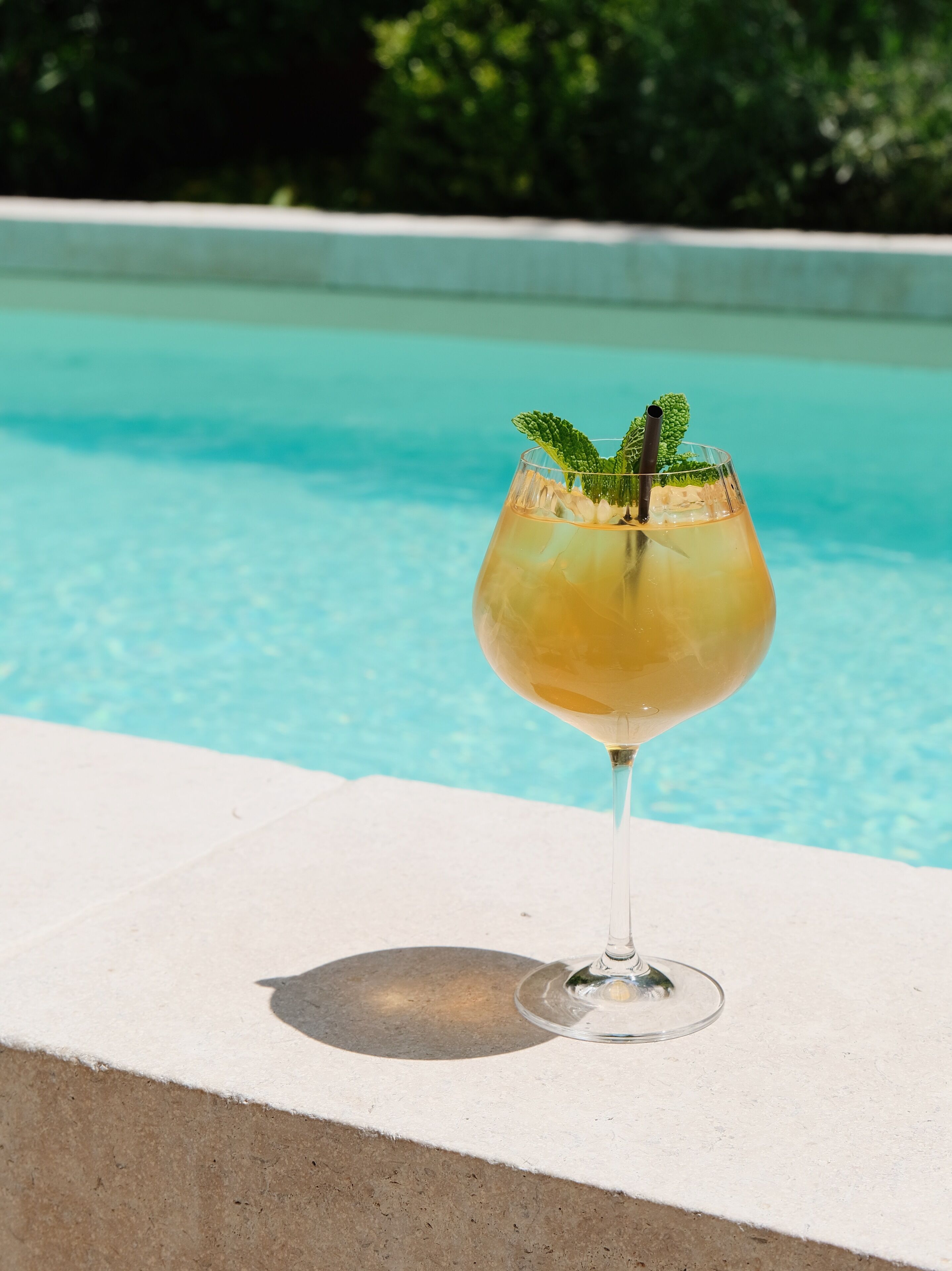 Una piscina al aire libre, sombrillas, sillones reclinables de piscina