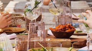 A dining table with various dishes, glasses, and a pitcher. - Hôtel SOCLO (Toulouse)
