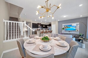 Luxurious open concept kitchen and dining area of the townhouse in Polk County, Florida - Fully stocked kitchen ready for culinary adventures - Seating for six in the dining area - Opulent finishes and impeccable craftsmanship - Elegant 5BR Townhouse w Pool near Disney (Davenport)