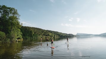 A calm lake with paddleboarders.