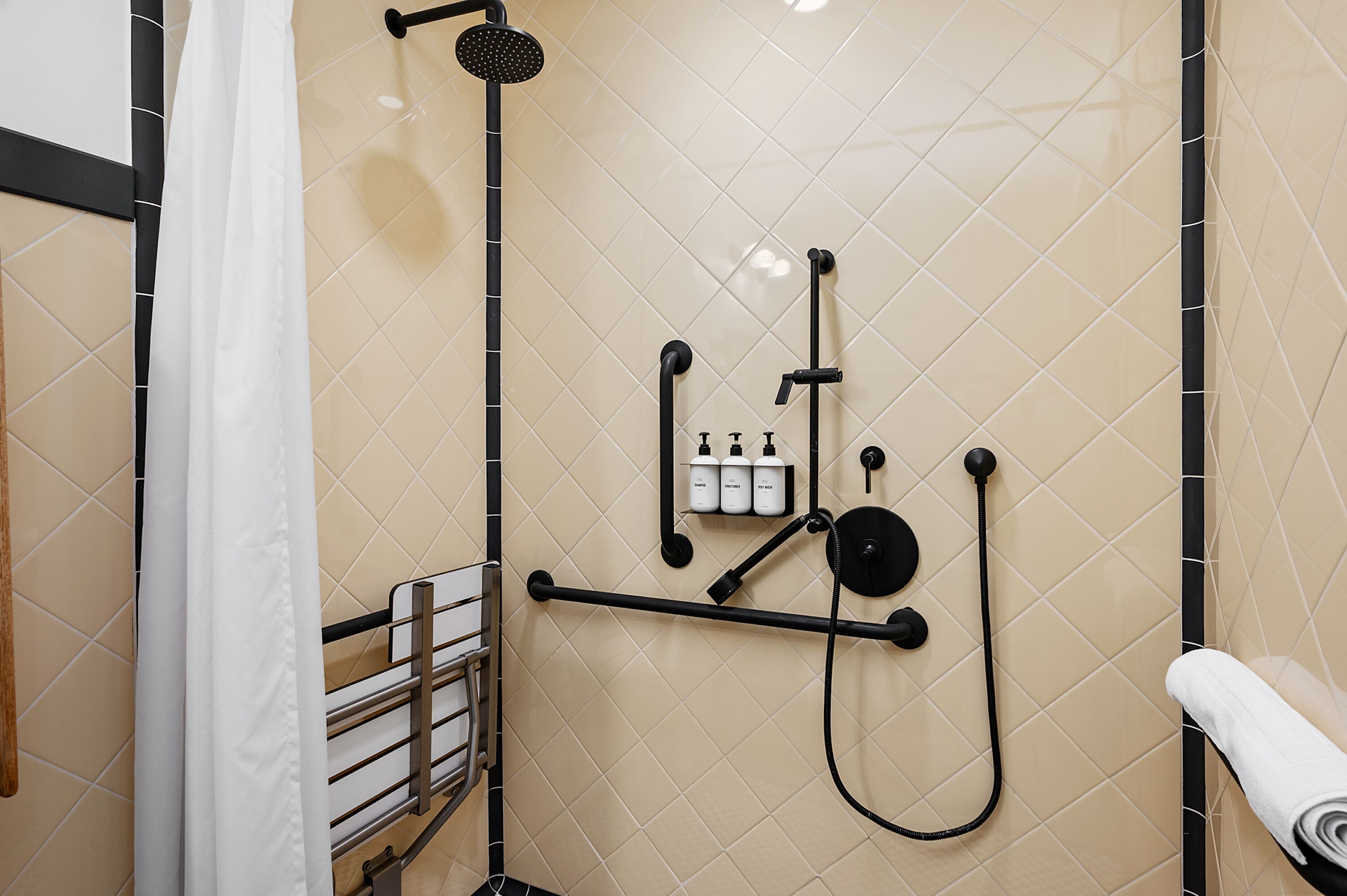Ein modernes Duschbad mit Handbrause, Wandarmatur und Handtuchhalter.