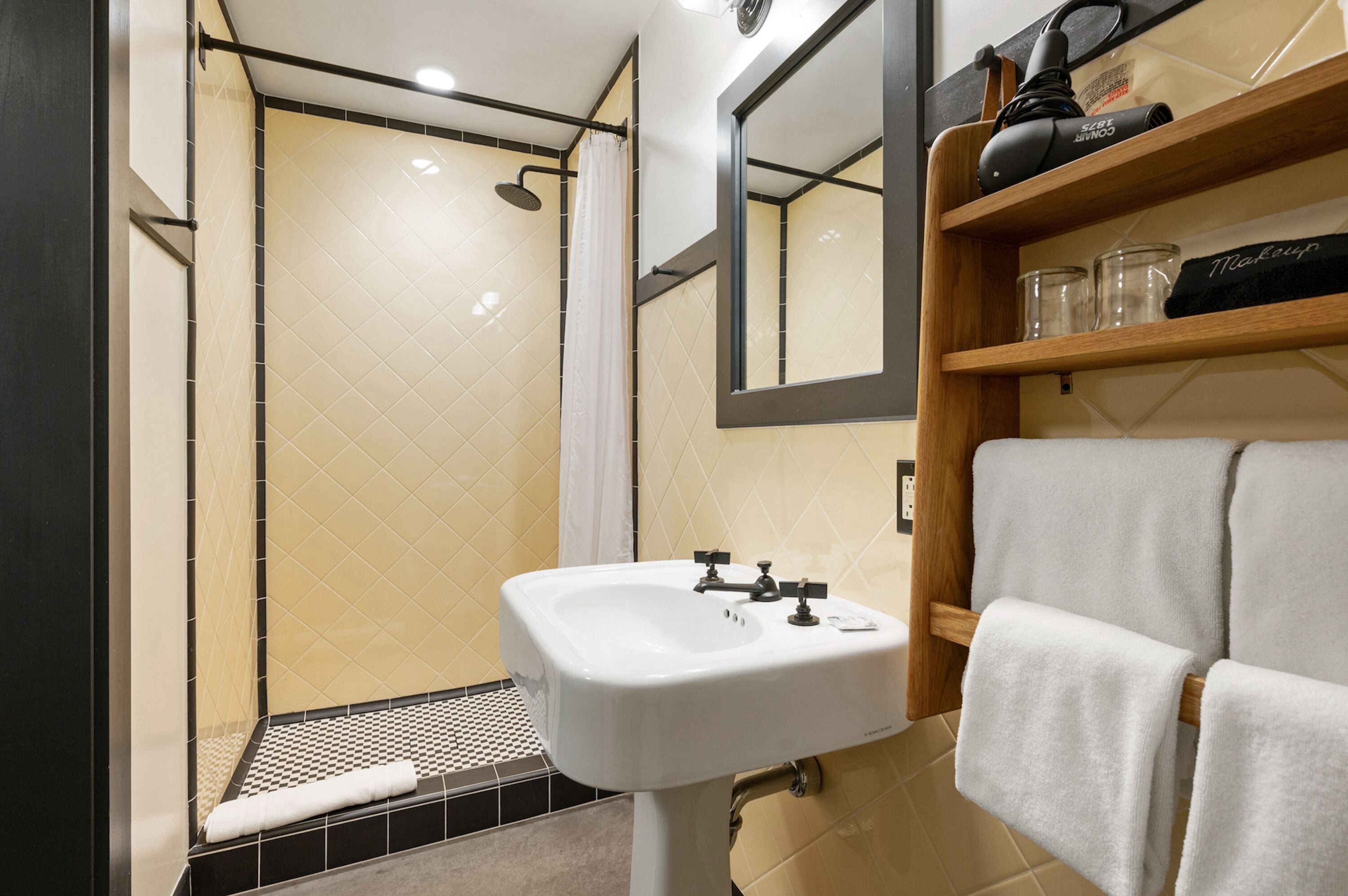 A modern bathroom with a shower, sink, and a mirror.